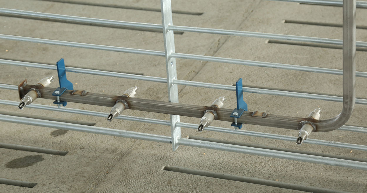 The Hog Slat nursery pig nipple bar provides weaned pigs with an additional, easy to access water source when starting new groups on wet/dry feeders. (Shown: 8 nipple bar model with painted mounting hook kit.)
